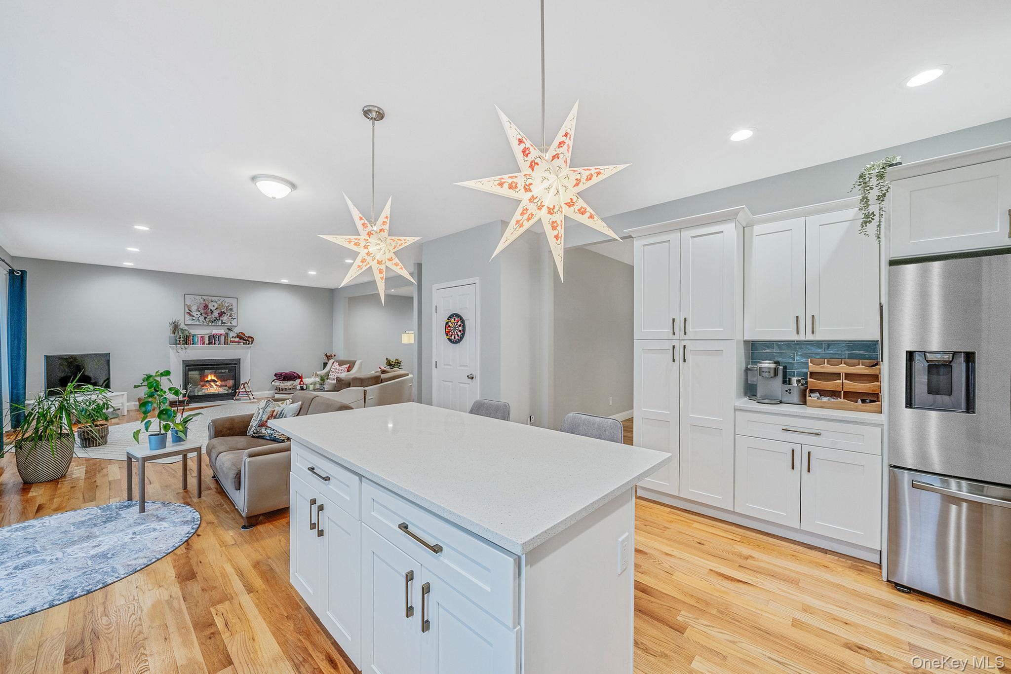 152 Wood Road Centereach, NY 11720 - Photo 16 of 35 a kitchen with stainless steel appliances a stove a sink dishwasher a refrigerator white cabinets and wooden floor