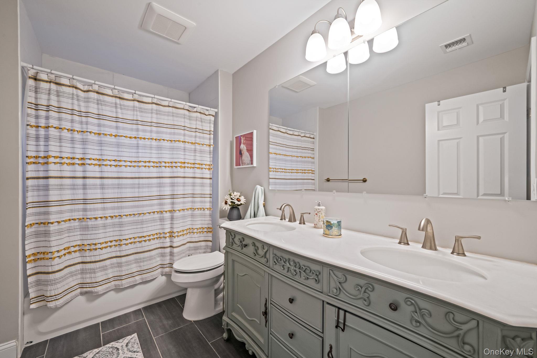 152 Wood Road Centereach, NY 11720 - Photo 26 of 35 a bathroom with a sink a toilet and shower curtain