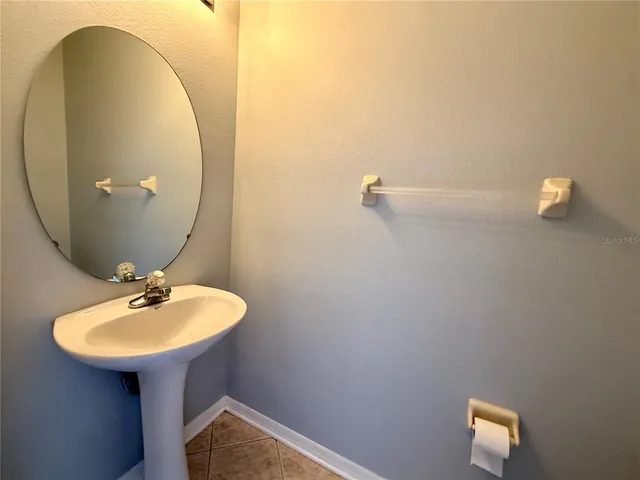 a bathroom with a sink a mirror and a lamp