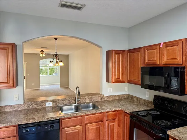 a kitchen with granite countertop stainless steel appliances a stove sink and microwave
