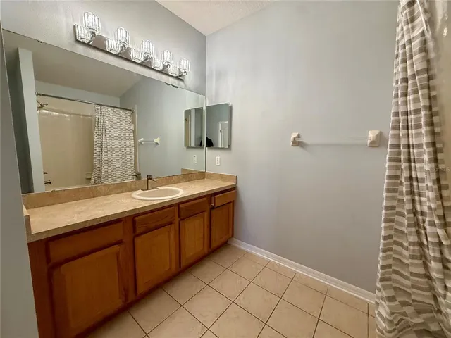 a bathroom with a sink a toilet a mirror and shower