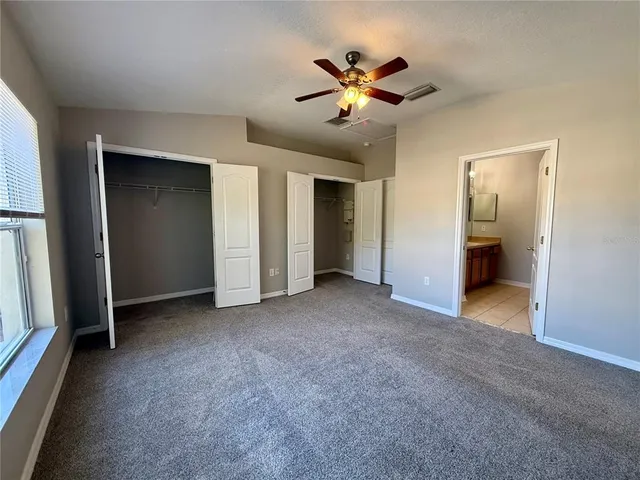 a view of a livingroom with a chandelier fan and closet