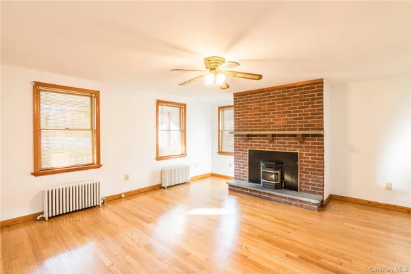 an empty room with windows and fireplace
