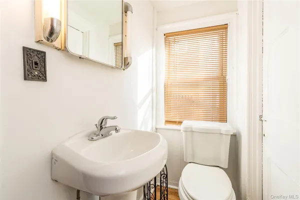 a bathroom with a sink a toilet and mirror