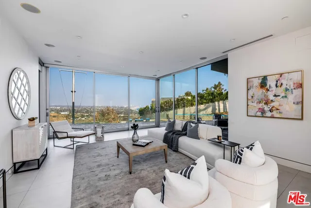 a kitchen with stainless steel appliances a stove a sink island and chairs in it