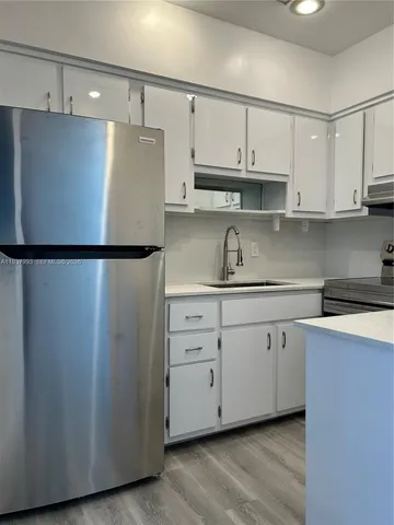 a kitchen with stainless steel appliances a refrigerator and cabinets