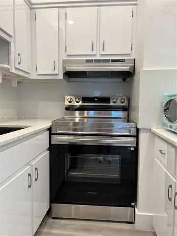 a stove top oven sitting inside of a kitchen