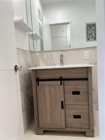 a bathroom with a sink a mirror and cabinets