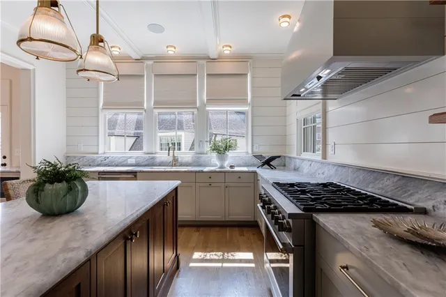 a kitchen with a table chairs stove and wooden floor