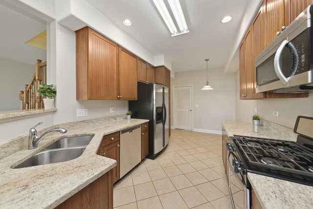 522 Telluride Court Bartlett, IL 60103 - Photo 6 of 18 a kitchen that has a sink a stove and a wooden cabinets