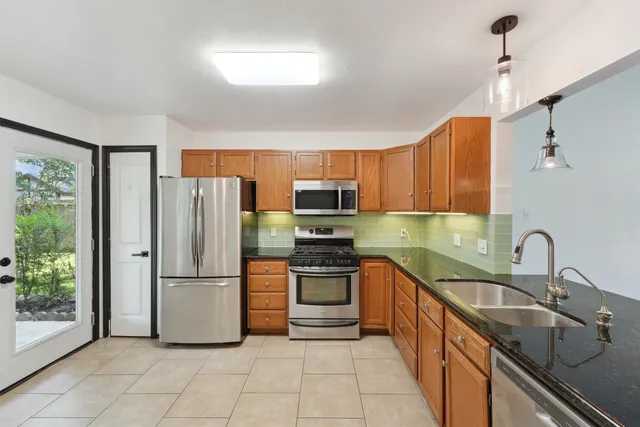 a kitchen with stainless steel appliances granite countertop a refrigerator sink and stove