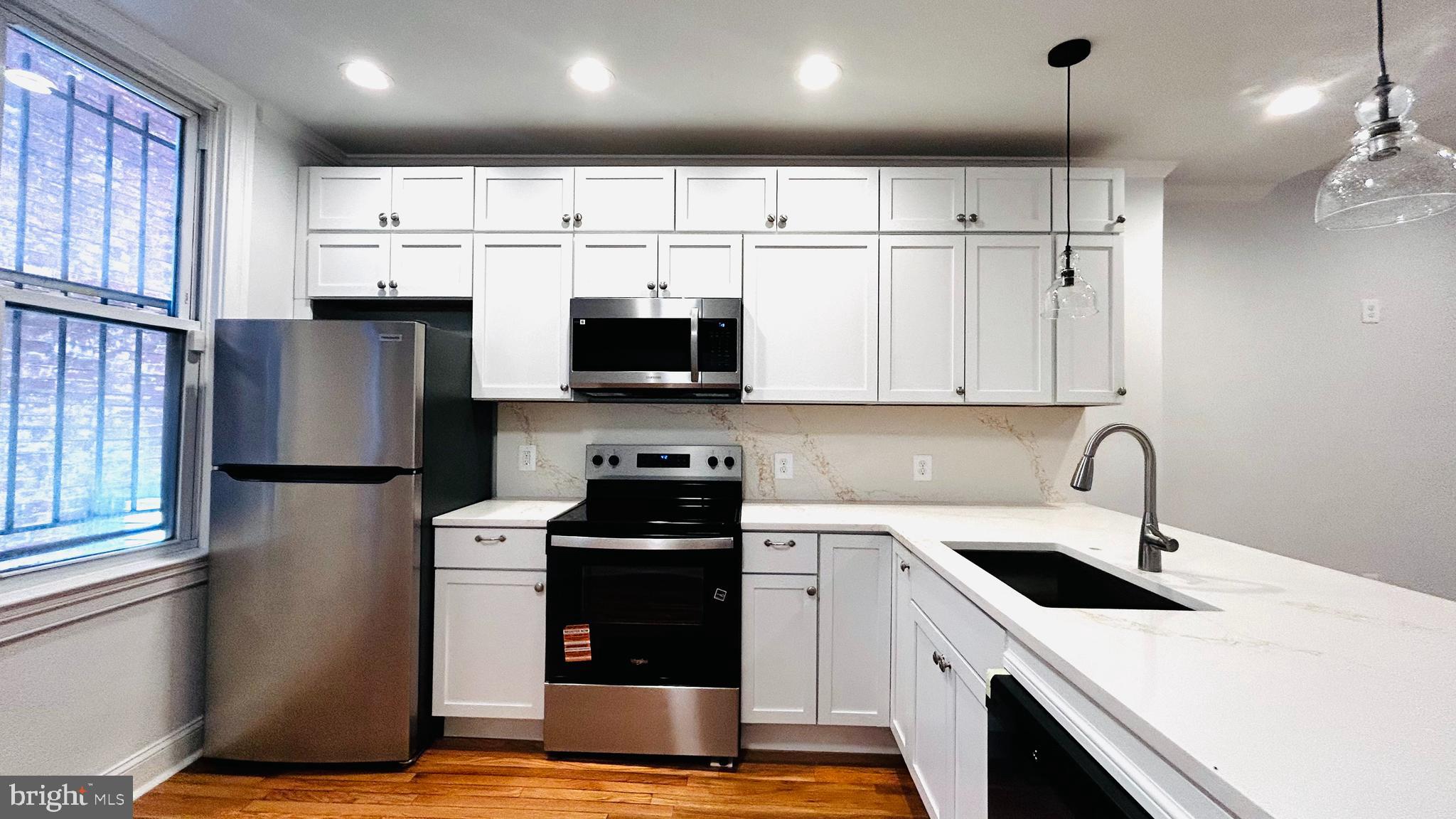 1724 18th Street Northwest, Unit 1 Washington, DC 20009 - Photo 1 of 11 a kitchen with stainless steel appliances a stove a sink a microwave and cabinets