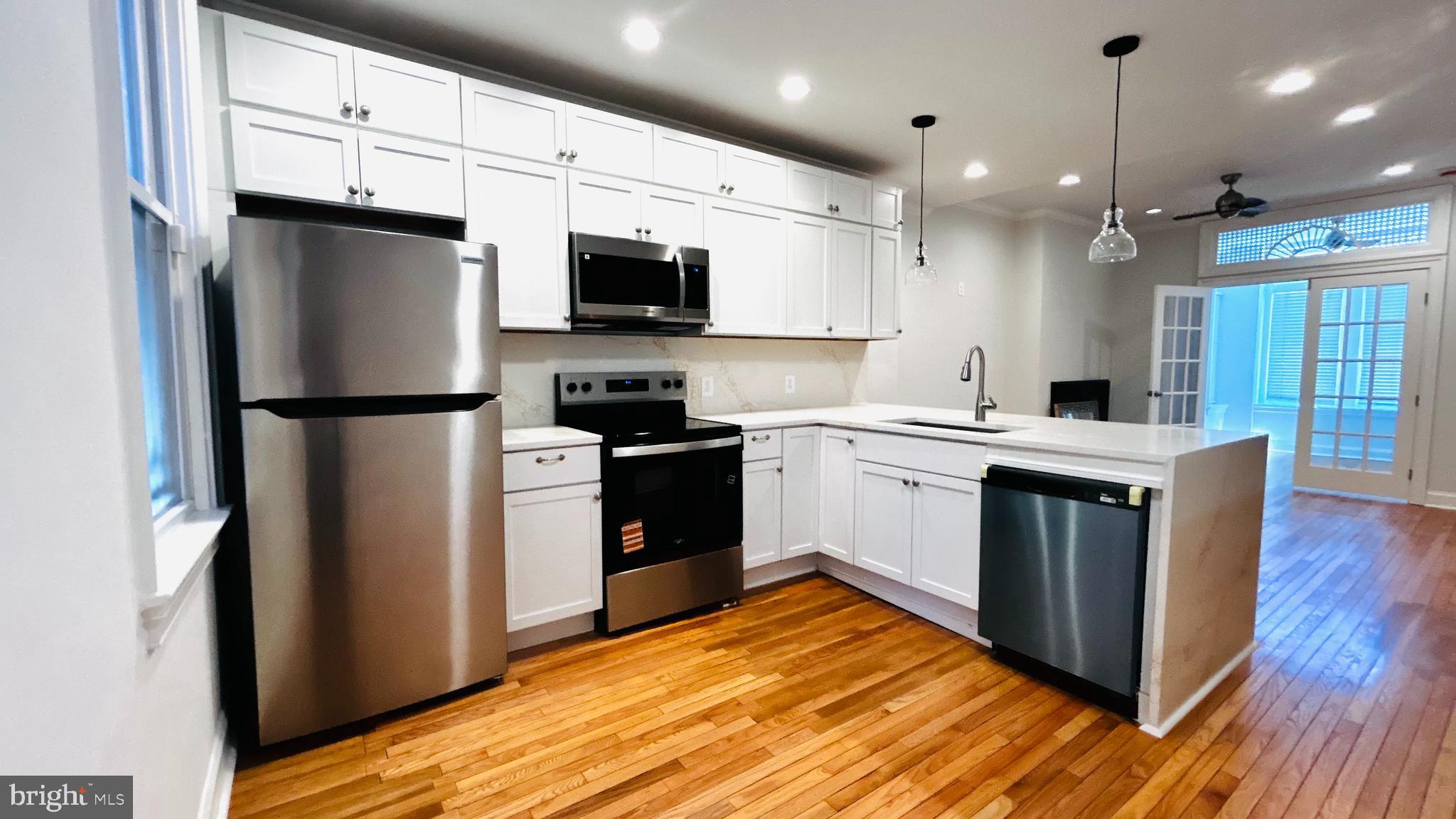 1724 18th Street Northwest, Unit 1 Washington, DC 20009 - Photo 2 of 11 a kitchen with stainless steel appliances a refrigerator stove and microwave