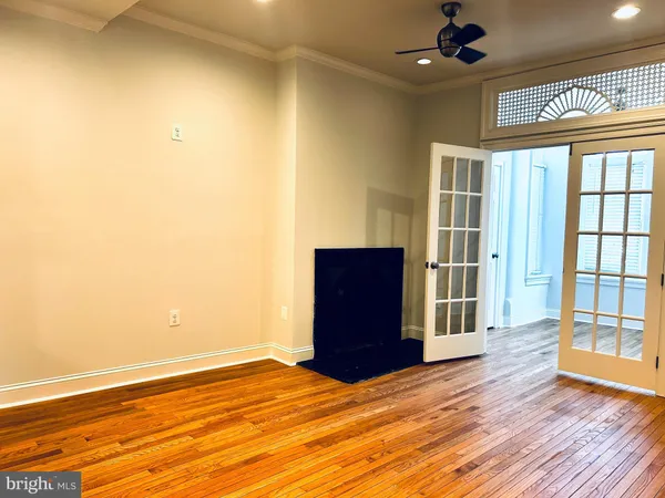 a view of empty room with a window and wooden floor