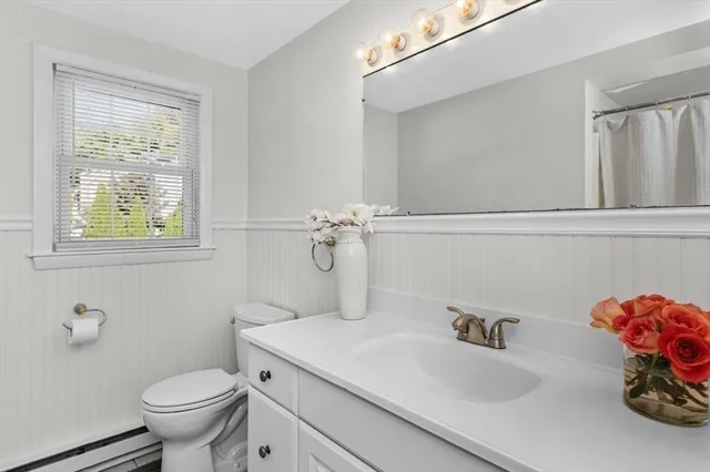 a bathroom with a sink vanity mirror and toilet