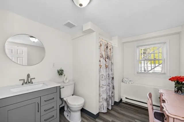a bathroom with a granite countertop toilet a sink and a mirror
