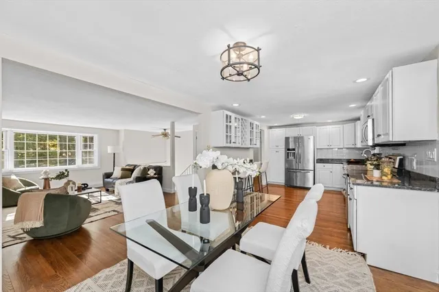 a living room with furniture kitchen view and a large window