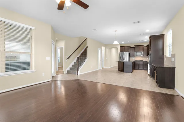 a view of empty room with wooden floor and window