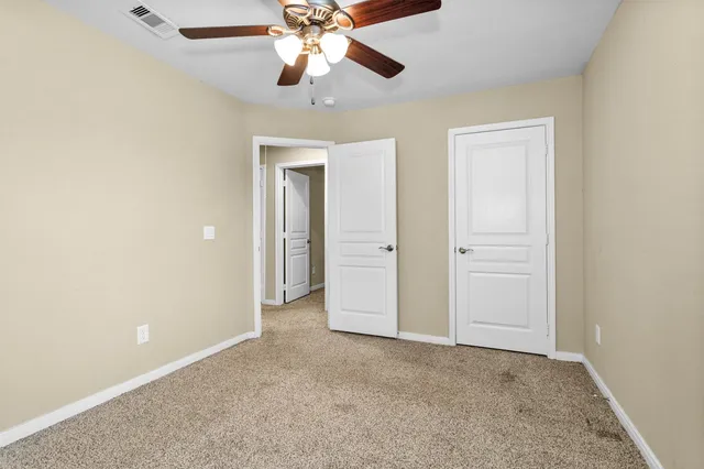 an empty room with a empty space and a ceiling fan