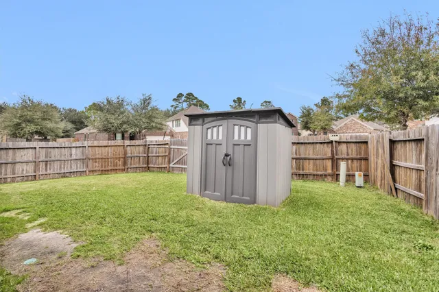 a view of a backyard with a garden and wooden fence
