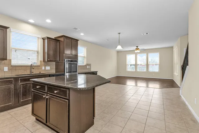 a kitchen with stainless steel appliances granite countertop a sink stove and cabinets
