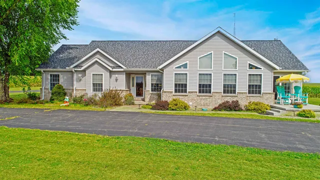 a front view of a house with a yard and potted plants