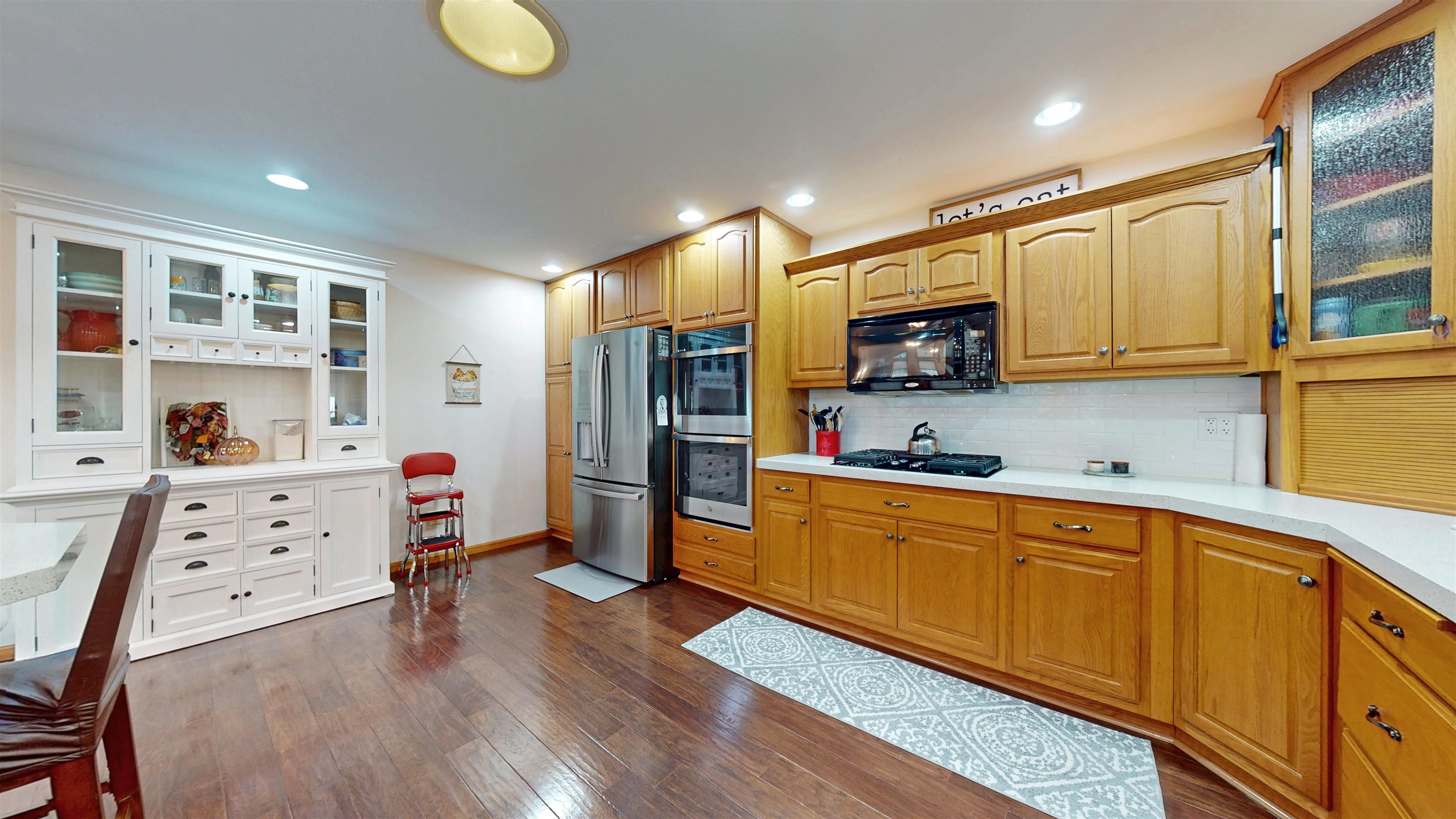 7821 Oakville Road Mount Carroll, IL 61053 - Photo 11 of 50 a kitchen with stainless steel appliances a stove a sink cabinets and a wooden floor