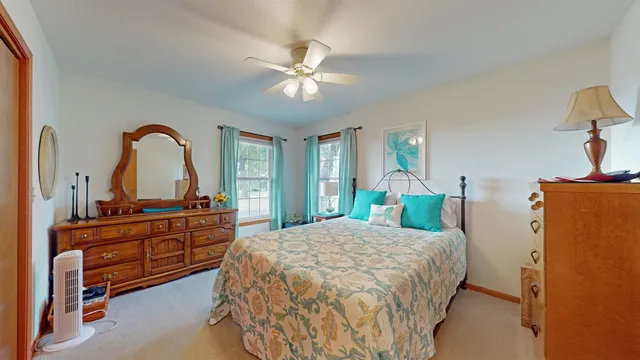 a bedroom with a bed and a dresser with mirror