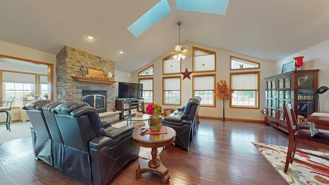 a living room with fireplace furniture and a large window