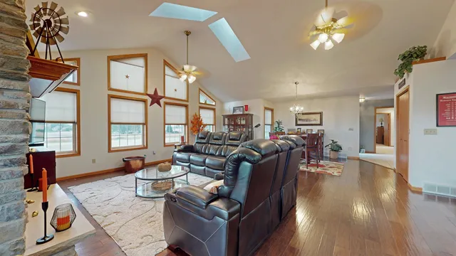 a living room with furniture a dining table with wooden floor and a chandelier