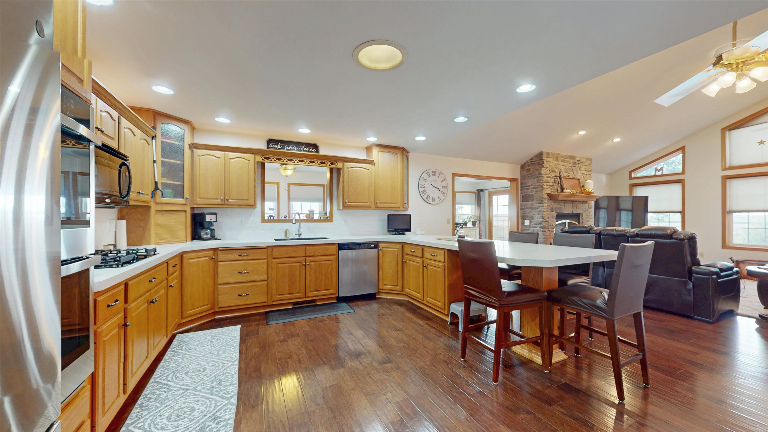 7821 Oakville Road Mount Carroll, IL 61053 - Photo 10 of 50 a kitchen with stainless steel appliances kitchen island granite countertop wooden floors and white cabinets
