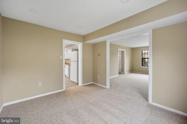 a view of an empty room with closet and a window