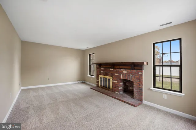 a living room with fireplace and a window