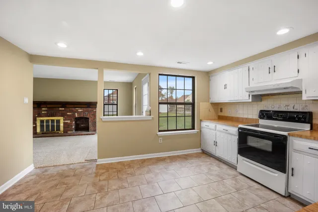 a kitchen with granite countertop a stove sink and cabinets