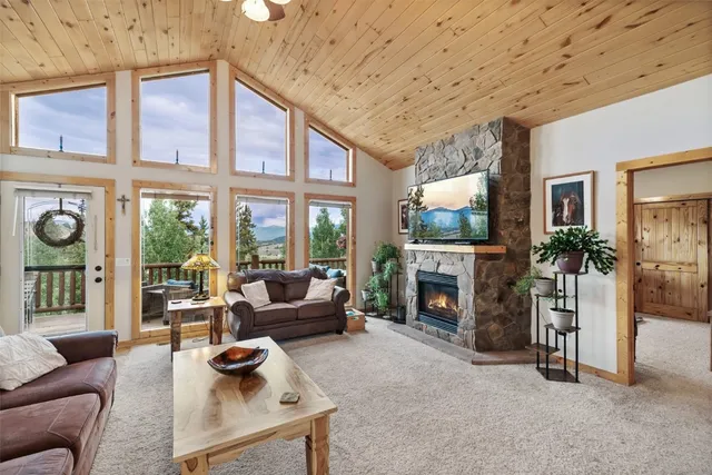 a living room with furniture a fireplace and a large window