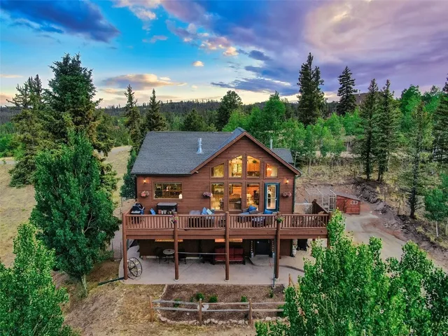 an aerial view of a house with swimming pool and outdoor seating