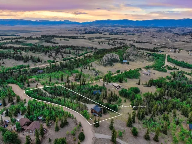 an aerial view of a house with a mountain
