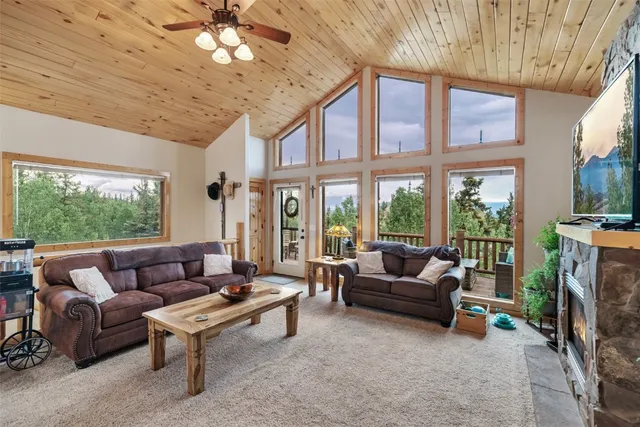a living room with furniture a flat screen tv and a floor to ceiling window