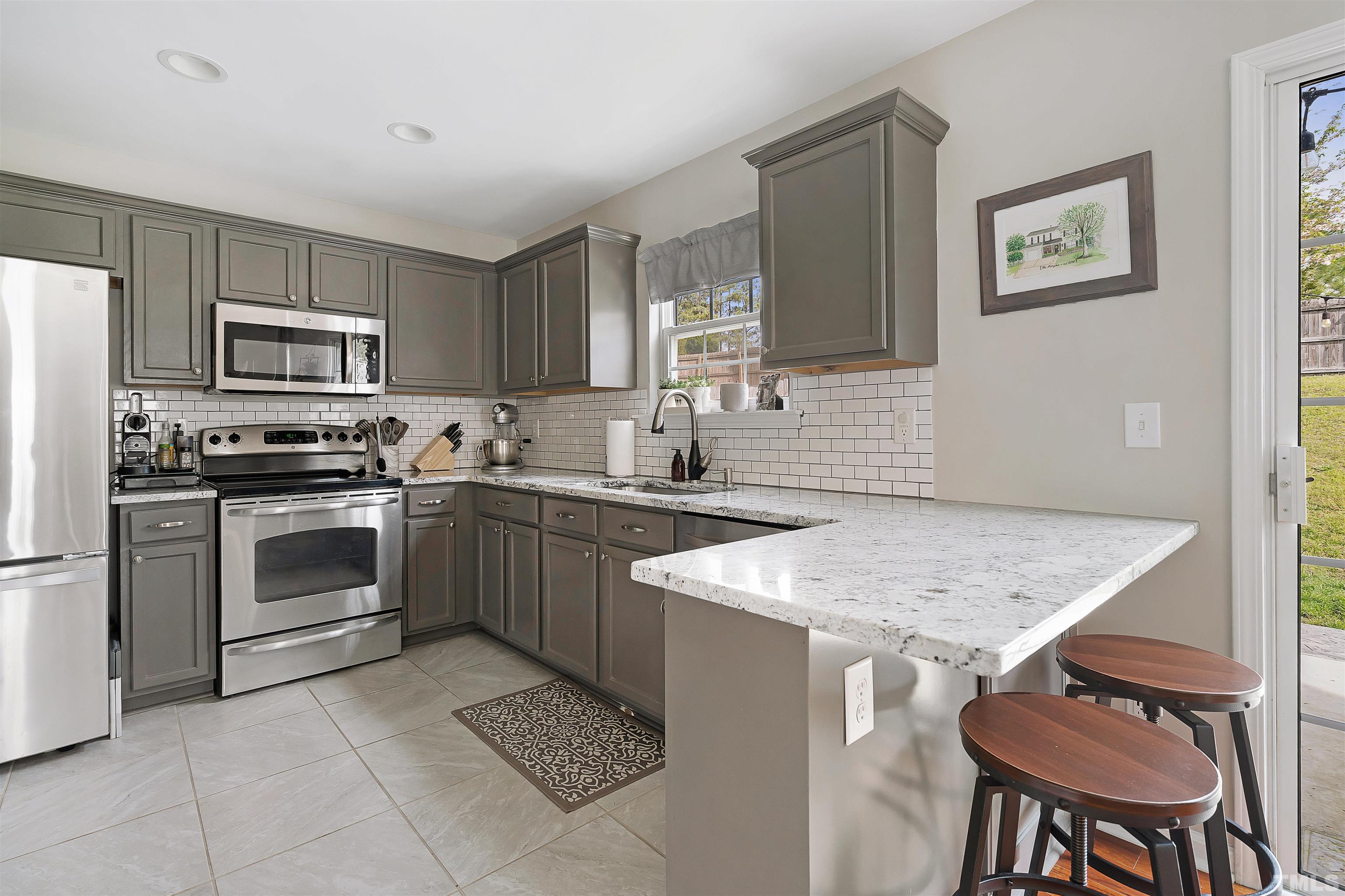 12440 North Exeter Way Durham, NC 27703 - Photo 15 of 36 a kitchen with a stove a sink and a refrigerator