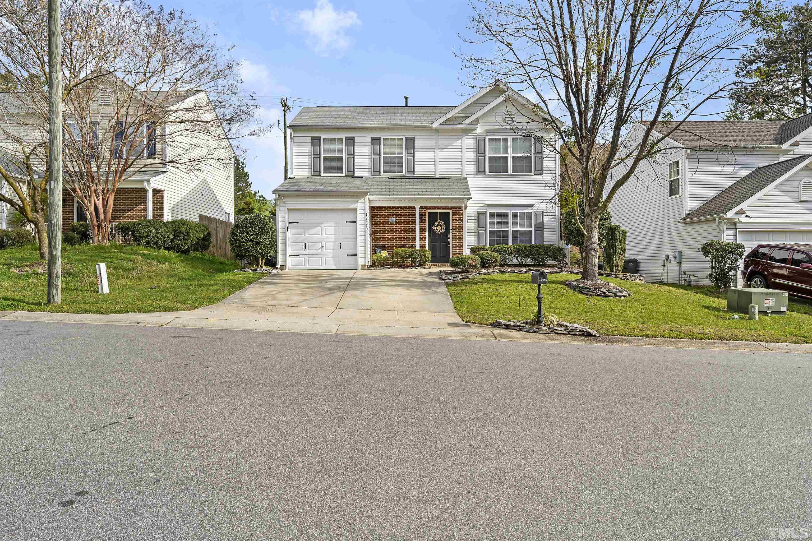 12440 North Exeter Way Durham, NC 27703 - Photo 2 of 36 a front view of a house with a yard and trees
