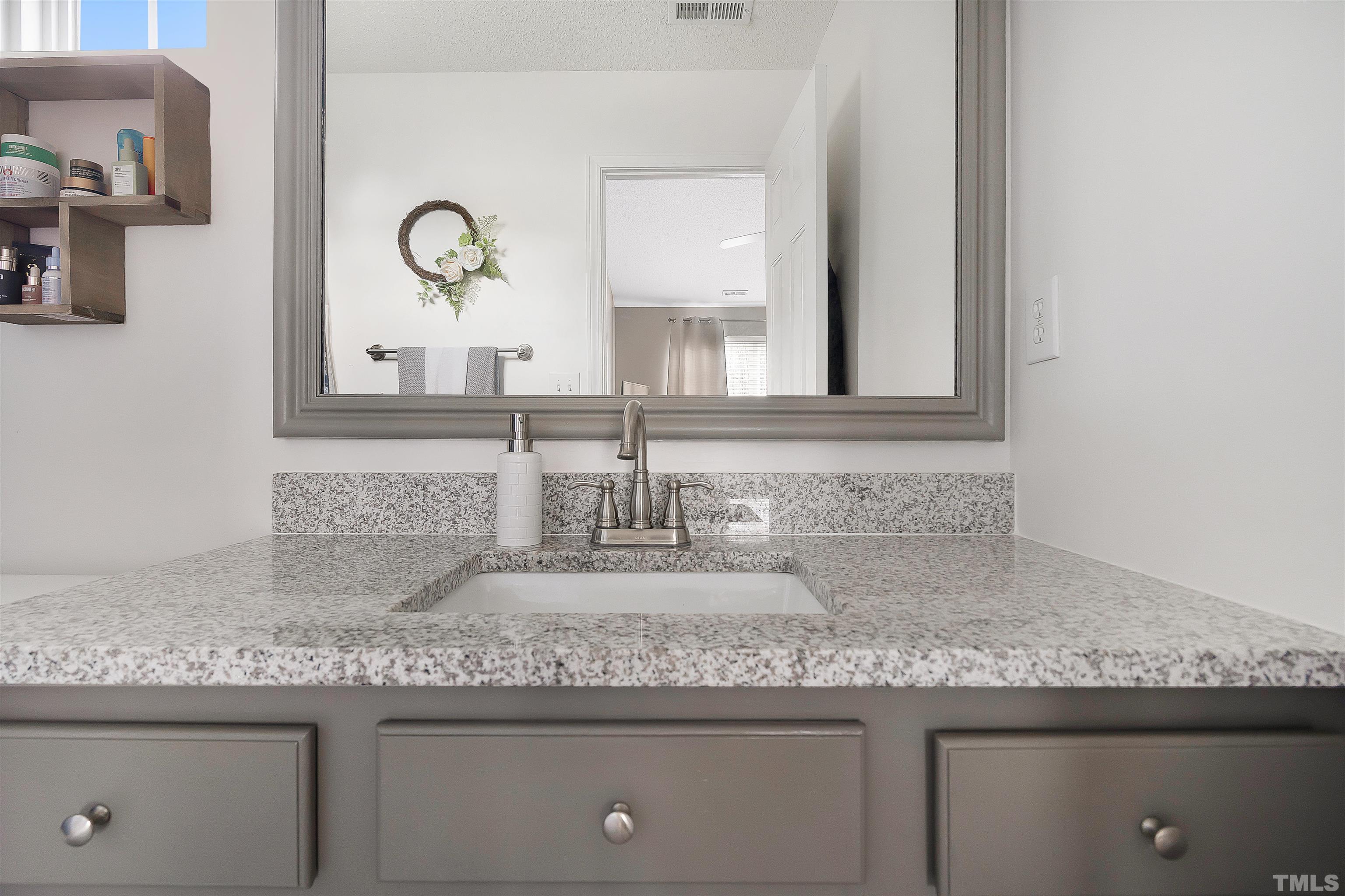 12440 North Exeter Way Durham, NC 27703 - Photo 24 of 36 a bathroom with a granite countertop sink and a mirror