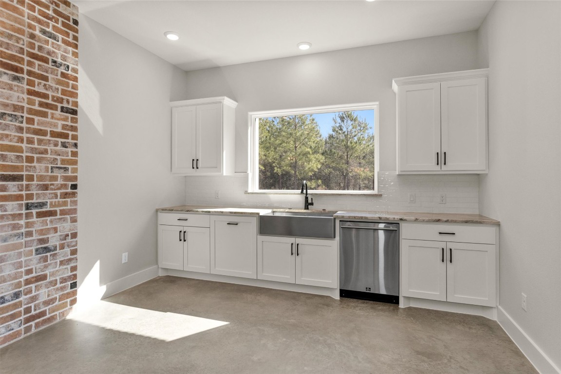 12744 Oak Barrel Road Willis, TX 77378 - Photo 17 of 50 A large picture window above the kitchen sink fills the space with natural light and offers peaceful views of the backyard, creating a bright and welcoming atmosphere while you cook or clean. This thoughtful placement keeps you connected to the outdoors and enhances the open feel of the kitchen.
Functionality meets convenience with a built-in pull-out trash drawer, seamlessly integrated into the cabinetry. Designed to maintain a clean, streamlined look.