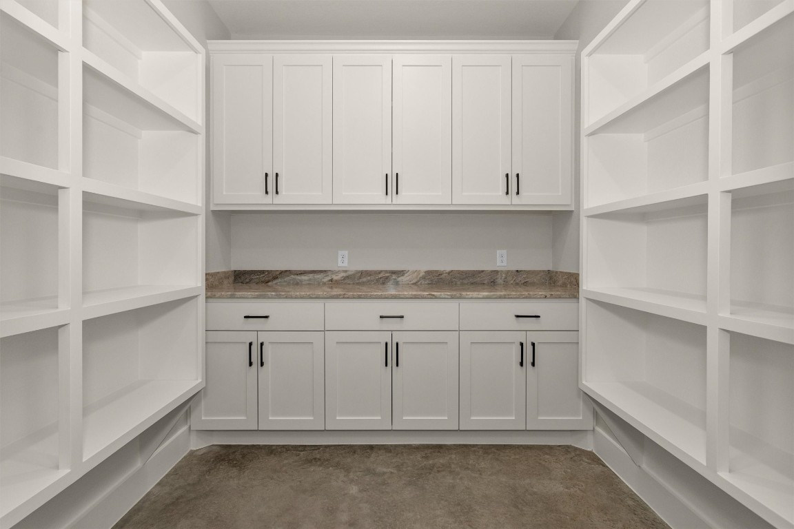 12744 Oak Barrel Road Willis, TX 77378 - Photo 18 of 50 The home features a spacious walk-in pantry with abundant shelving and cabinetry, providing exceptional storage and organization. Complete with countertop space, it’s perfect for small appliances, food prep, and even creating a charming coffee bar setup. A functional and stylish extension of the kitchen, this pantry offers both convenience and versatility.