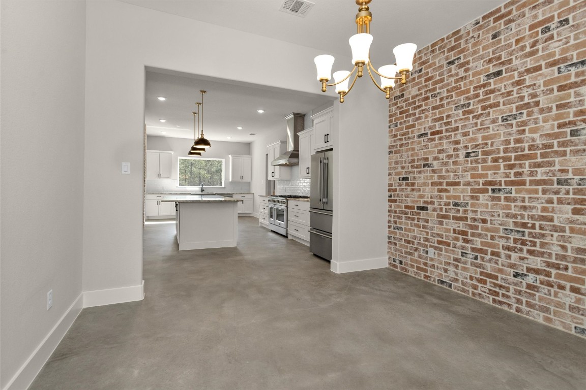 12744 Oak Barrel Road Willis, TX 77378 - Photo 19 of 50 Just off the kitchen, the spacious dining area offers the perfect setting for gatherings both large and intimate. The room is beautifully anchored by a stunning brick accent wall, adding warmth, texture, and timeless character to the space.