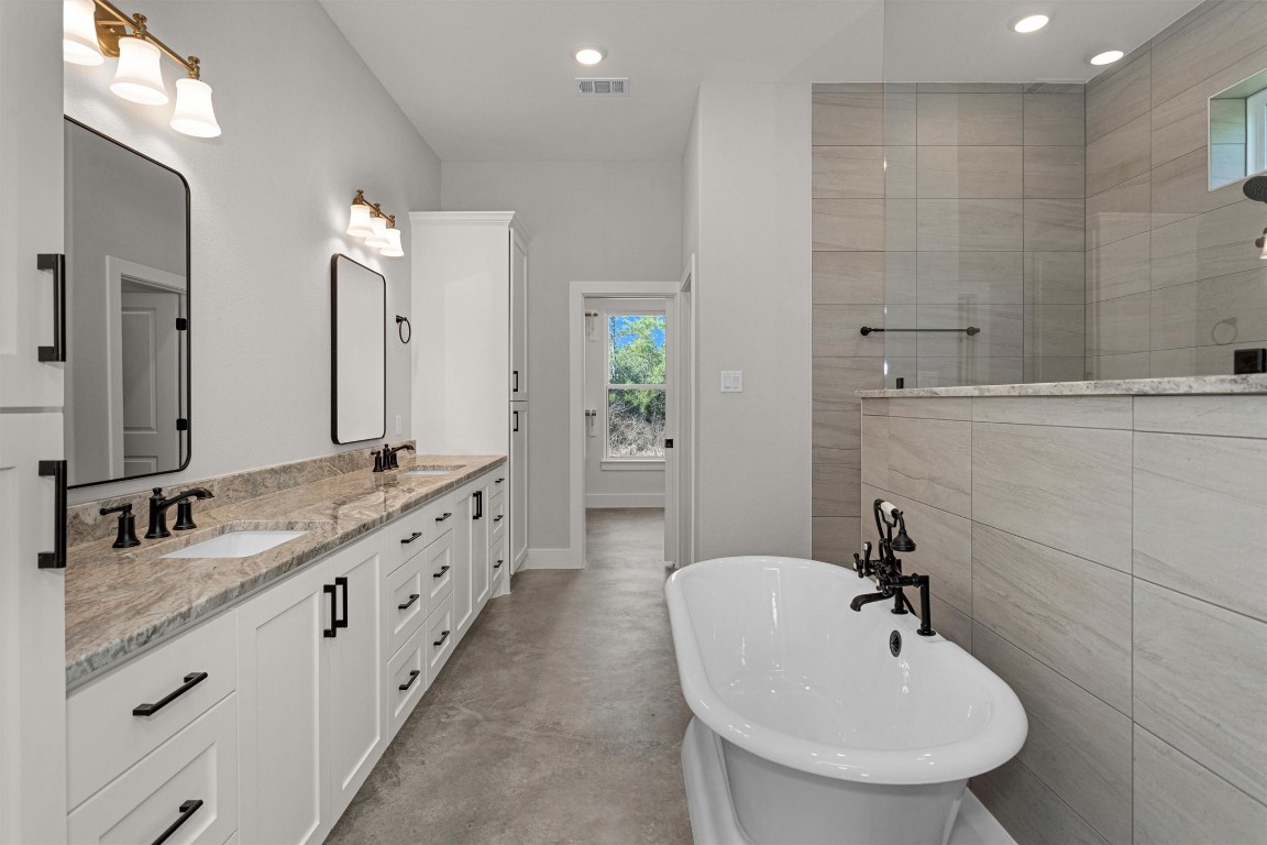 12744 Oak Barrel Road Willis, TX 77378 - Photo 23 of 50 The primary bath is thoughtfully designed to offer both luxury and functionality. Featuring dual sinks with ample counter space, this layout provides comfort and convenience for daily routines.