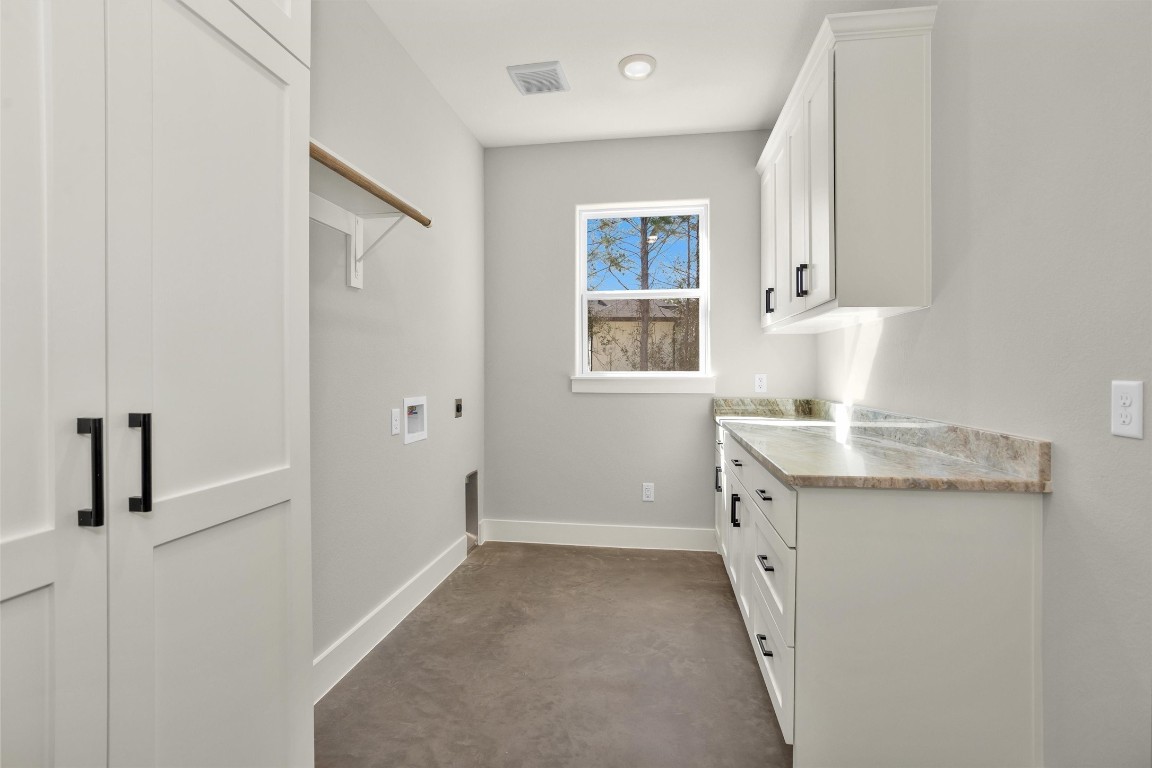 12744 Oak Barrel Road Willis, TX 77378 - Photo 37 of 50 The oversized utility room offers exceptional space and functionality, complete with additional closets, ample cabinetry, and generous countertop space for folding and organizing. Designed with storage in mind, this well-appointed area keeps household essentials neatly tucked away while providing room to move comfortably.