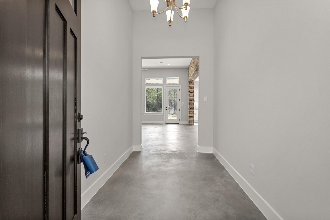 12744 Oak Barrel Road Willis, TX 77378 - Photo 6 of 50 Step into the inviting foyer where sleek sealed concrete flooring immediately makes a statement. This durable and stylish finish flows seamlessly throughout the home, creating a cohesive look while offering low-maintenance convenience.
The smooth, polished surface adds a modern touch with subtle texture and warmth, complementing the home’s architectural details. Designed for both beauty and practicality, the sealed concrete floors provide lasting durability.