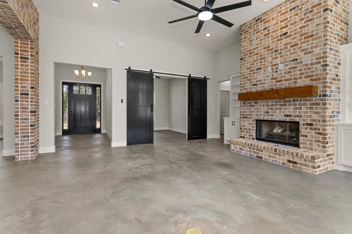 12744 Oak Barrel Road Willis, TX 77378 - Photo 9 of 50 Just beyond the striking double barn doors off the living room, you’ll find a versatile office, study, or library space designed for both privacy and style. The doors add a touch of rustic charm while allowing the room to feel connected to the main living area when open — and tucked away for quiet focus when closed.