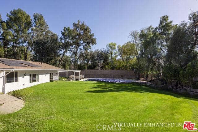 23760 Oakfield Road Hidden Hills, CA 91302 - Photo 18 of 23 a view of a house with a yard table and chairs