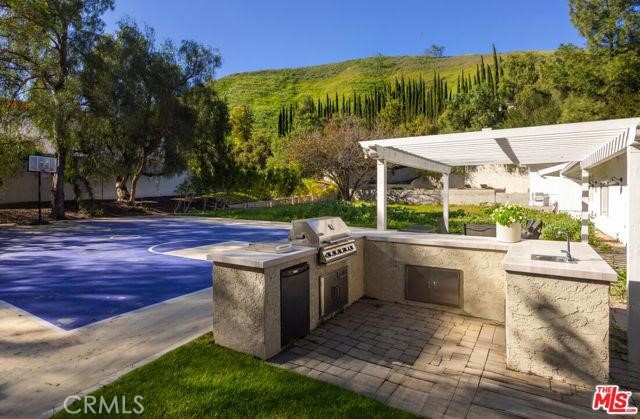 23760 Oakfield Road Hidden Hills, CA 91302 - Photo 19 of 23 a view of a patio with table and chairs potted plants and palm tree